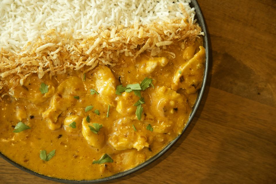 Strogonoff de frango with rice and crispy batata palha in a bowl.
